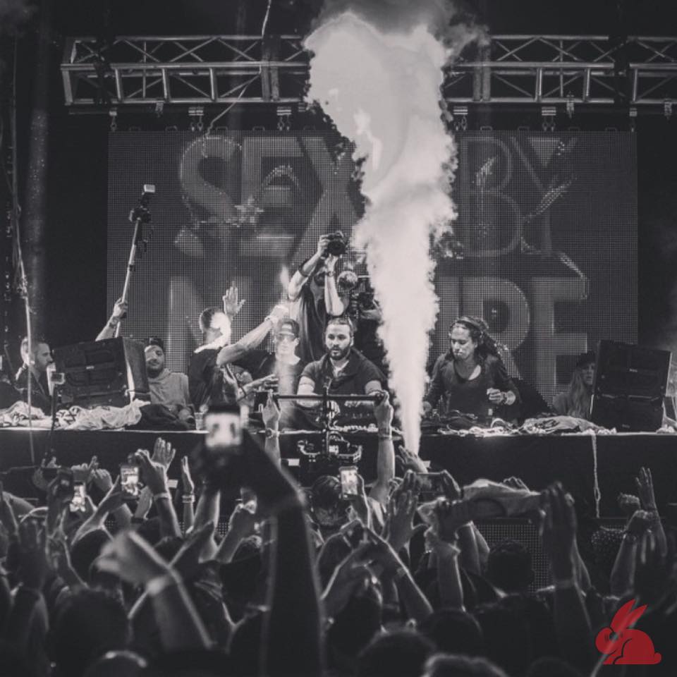 Black and white smoke jet rising over a packed crowd filming a Sexy By Nature set