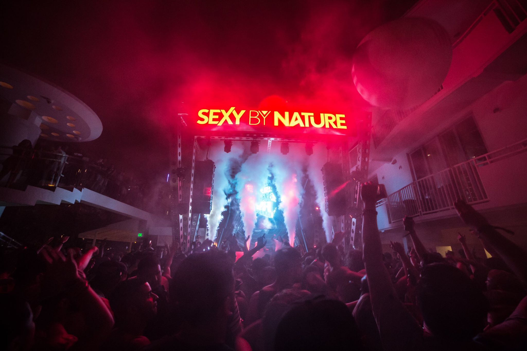 Stage and crowd under colored light at a Red Rabbit night party