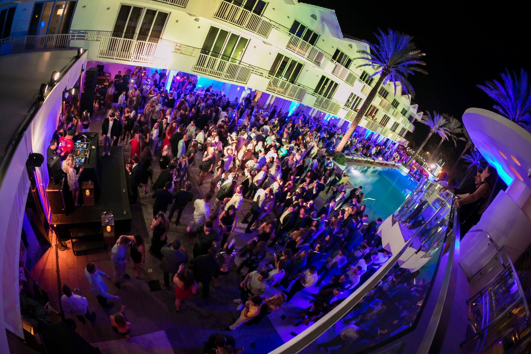 Fisheye view of the packed Delano pool deck lit purple and blue