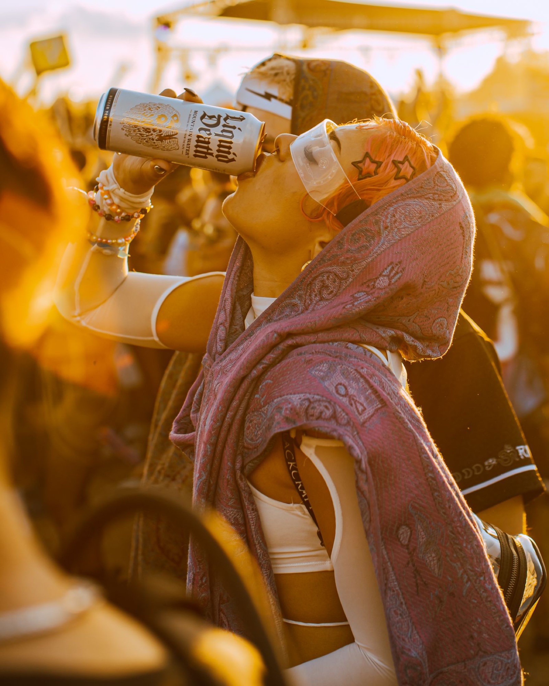 Liquid Death at golden hour in the festival crowd